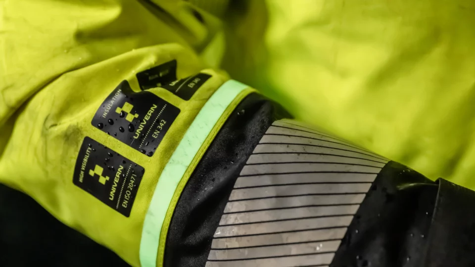Close-up of high-visibility jacket sleeve with safety labels and reflective strip