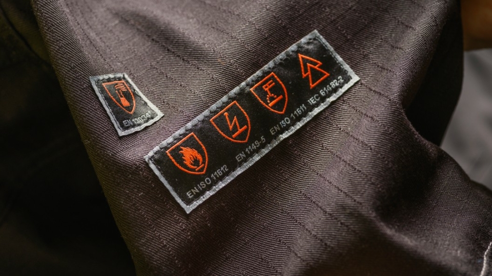 Close-up of safety standard labels on protective workwear fabric