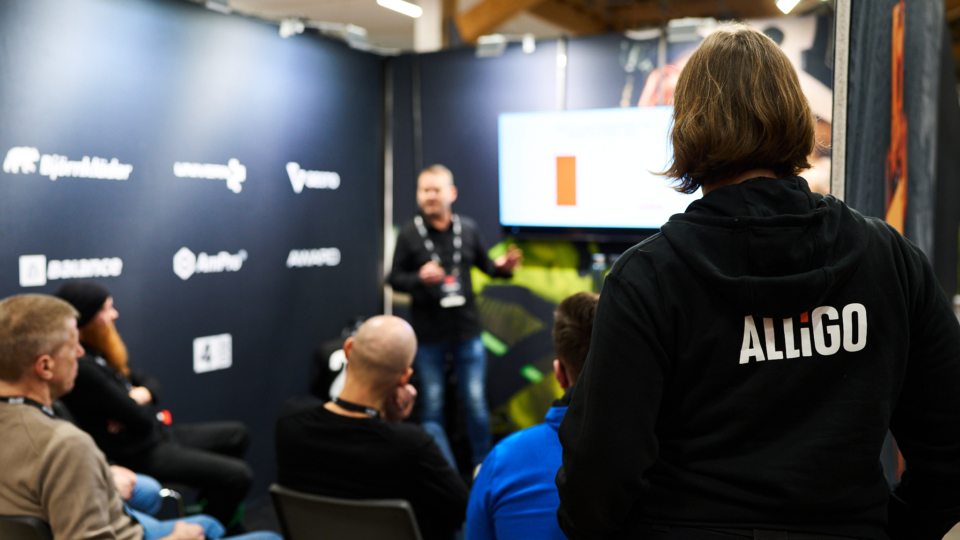 An Alligo employee attending a presentation at an indoor event