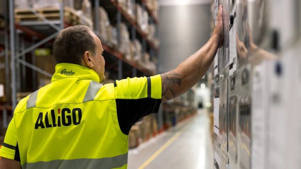 Alligo worker reviews posted notes on warehouse wall