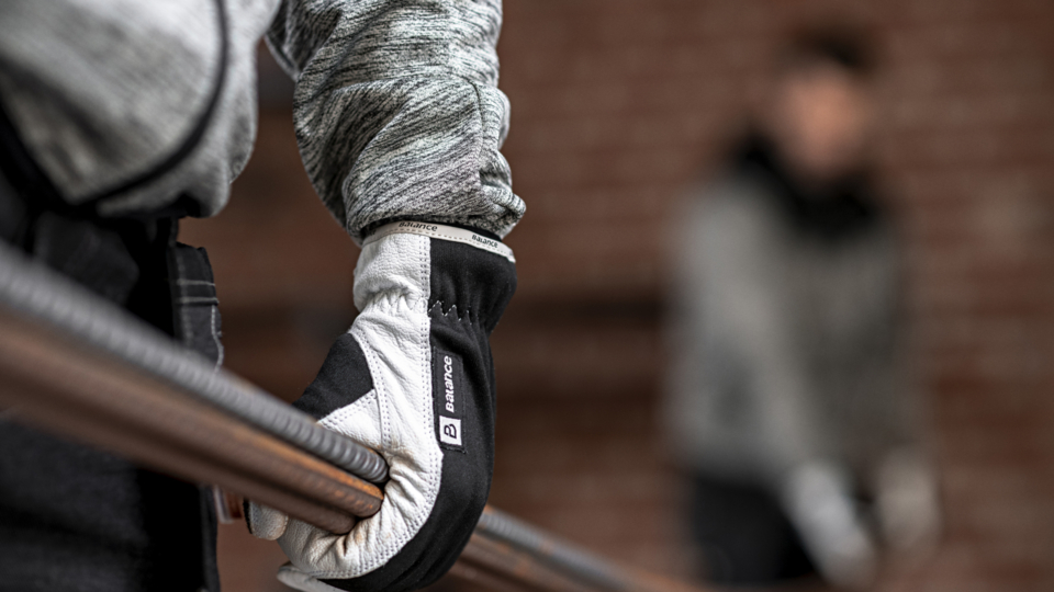 Worker wearing Balance glove grips a metal pipe firmly