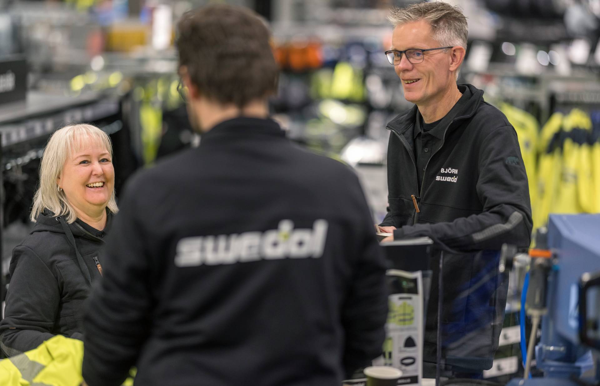 Swedol employees smiling and interacting with a customer in a store