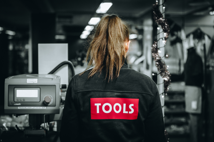 Employee in a TOOLS jacket in a workshop