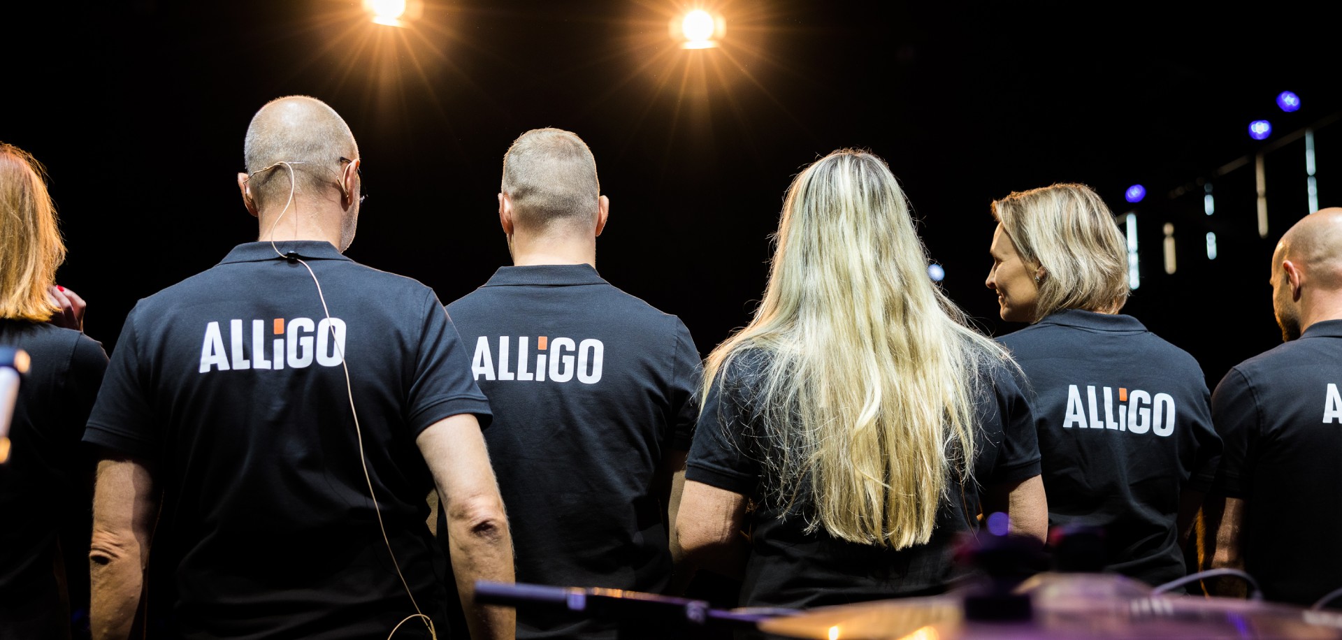 Alligo employees in branded shirts, seen from behind
