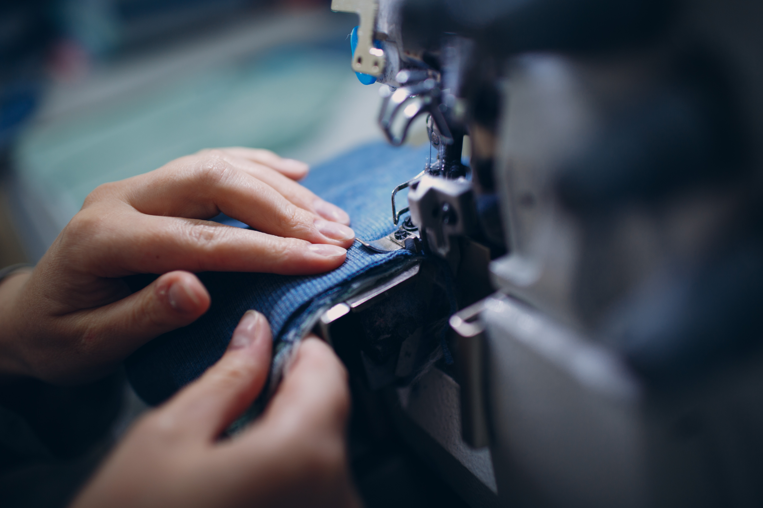 Seamstress sewing at a machine in a factory
