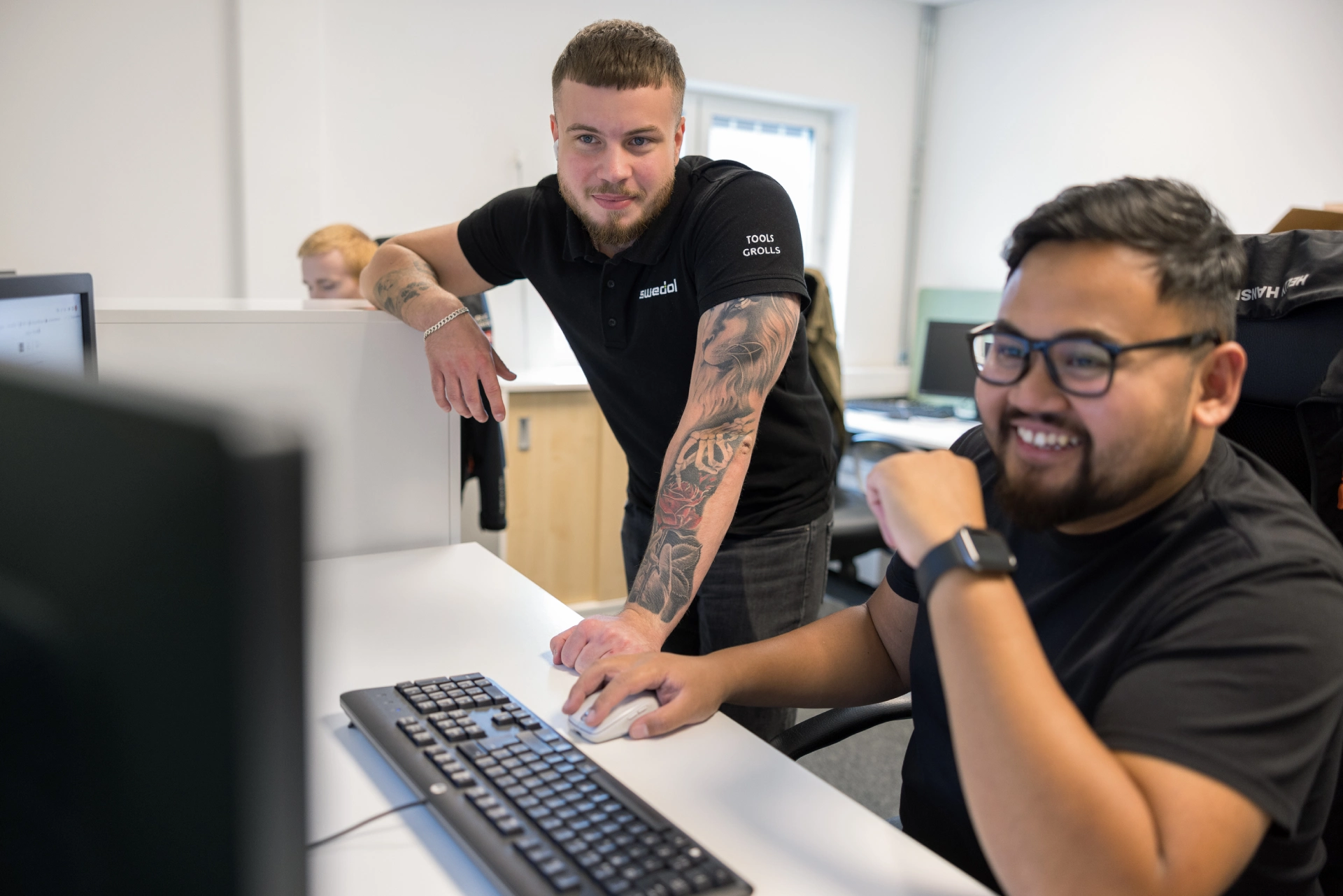 Employees talking at a computer