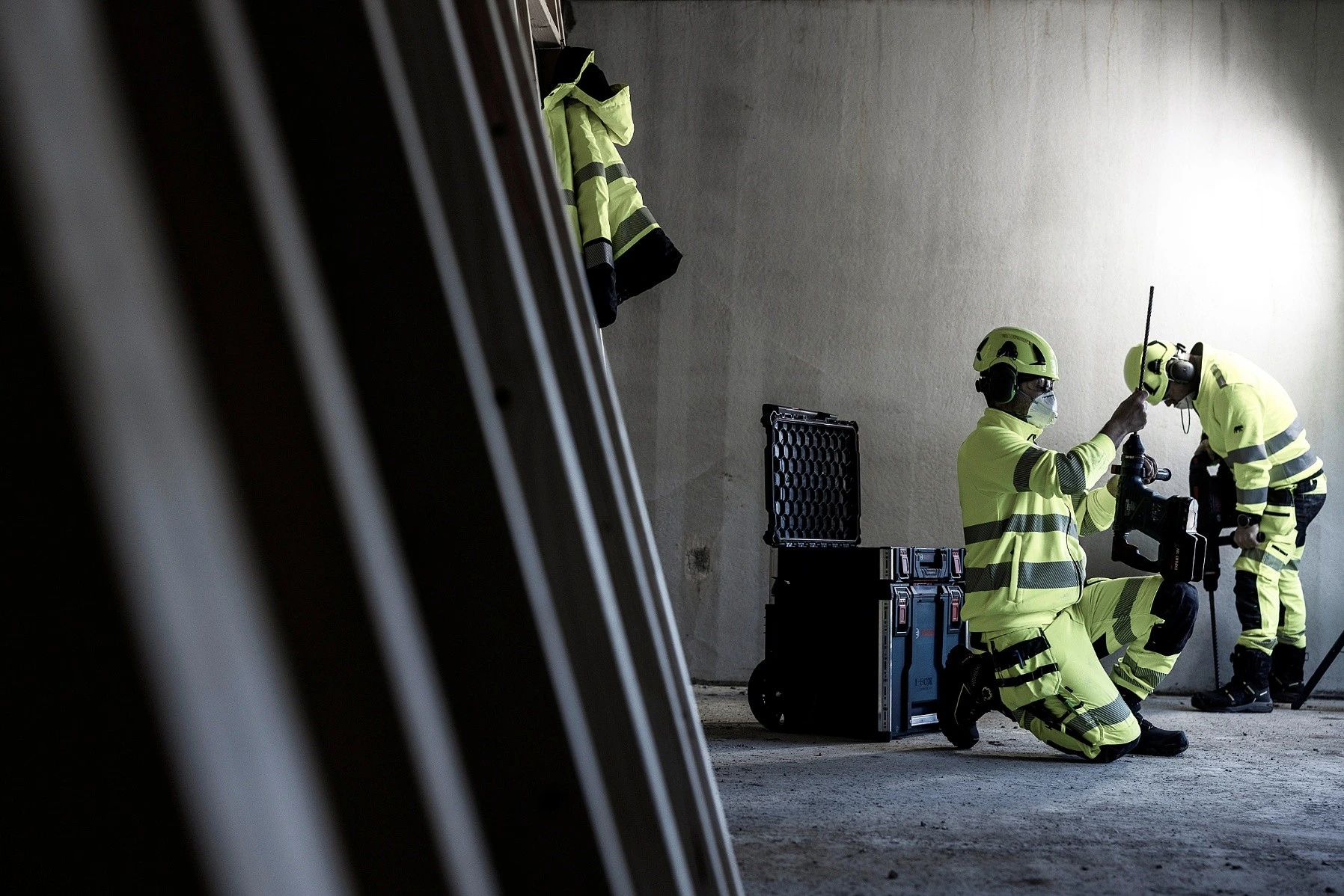 Arbetare med handskar hanterar säkerhetslina och sele vid höghöjdsarbete
